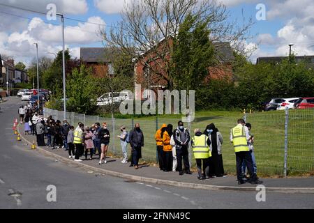 Les personnes faisant la queue pour la vaccination contre Covid à l'ESSA academy de Bolton comme la propagation de la variante du coronavirus indien pourrait conduire au retour des blocages locaux, ont reconnu les ministres. Bolton, Blackburn, Darwen et Bedford sont les domaines qui préoccupent le plus les ministres. Date de la photo: Mardi 18 mai 2021. Banque D'Images