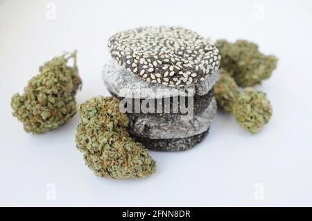 Cookies et bourgeons de marijuana isolés sur fond blanc. Fleurs et bonbons de cannabis. Chanvre récréation, cana cuisine, passe-temps, concept de légalisation. Banque D'Images