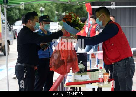 (210518) -- LU'AN, le 18 mai 2021 (Xinhua) -- UN membre du personnel (R) reçoit des produits de première nécessité pour les résidents en quarantaine à domicile dans une communauté de la ville de lu'an, province d'Anhui en Chine orientale, le 18 mai 2021. La ville de lu'an, dans la province d'Anhui, dans l'est de la Chine, a signalé lundi deux nouveaux cas asymptomatiques de COVID-19, a déclaré la commission sanitaire de la ville mardi. Lundi à 9 heures, lu'an avait enregistré cinq cas confirmés de transmission locale et neuf cas asymptomatiques, tous sous traitement dans des hôpitaux désignés. (Xinhua/Zhou Mu) Banque D'Images