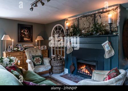 Bougies allumées sur la cheminée dans la pipe de duvet avec des bas de Noël dans le cottage géorgien, West Sussex. Banque D'Images