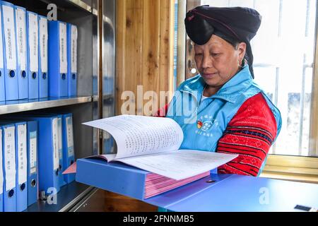 Nanning, Chine. 18 mai 2021. (210518) -- NANNING, 18 mai 2021 (Xinhua) -- Pan Jiping organise les dossiers de santé des villageois au village de Xiaozhai, canton de Longji, comté de Longsheng, région autonome de Guangxi Zhuang, dans le sud de la Chine, le 18 mai 2021. À Xiaozhai, un village au pied de la montagne de Fupingbao à plus de 1,900 mètres d'altitude, Pan Jiping est médecin de campagne ici depuis plus de 30 ans. PAN, 57 ans, est l'un des Hongyao, une branche du groupe ethnique Yao. Banque D'Images