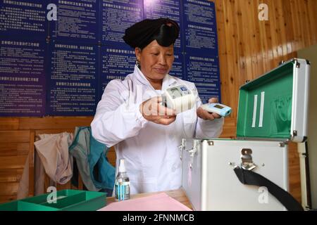 Nanning, Chine. 18 mai 2021. (210518) -- NANNING, le 18 mai 2021 (Xinhua) -- Pan Jiping prépare sa trousse d'urgence pour les visites à domicile au village de Xiaozhai, canton de Longji, comté de Longsheng, région autonome de Guangxi Zhuang, dans le sud de la Chine, le 18 mai 2021. À Xiaozhai, un village au pied de la montagne de Fupingbao à plus de 1,900 mètres d'altitude, Pan Jiping est médecin de campagne ici depuis plus de 30 ans. PAN, 57 ans, est l'un des Hongyao, une branche du groupe ethnique Yao. Banque D'Images