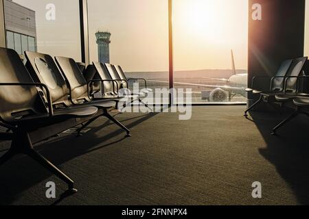 Chaises dans la salle d'attente à l'aéroport à la porte avec lumière du soleil Banque D'Images