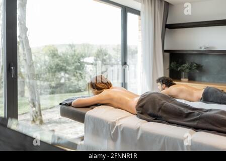 Beau couple allongé dans un salon de spa et attendant le masseur pour le massage profond du dos et la détente. Le bien-être et les loisirs pour les soins de santé ensemble. Banque D'Images