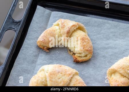 Croissants cuits à partir d'une pâte au fromage cottage avec du sucre sur une plaque de cuisson avec du papier parchemin qui vient d'être sorti du four. En-cas pour le petit-déjeuner. TH Banque D'Images