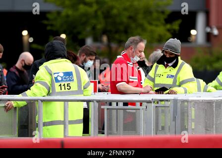Les fans de Manchester United passent des contrôles de sécurité à leur arrivée au stade avant le match de la Premier League à Old Trafford, Manchester. Date de la photo: Mardi 18 mai 2021. Banque D'Images