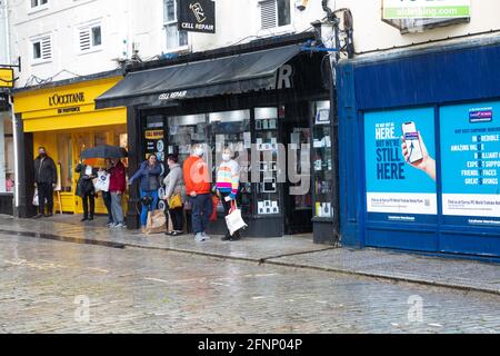 Truro, Royaume-Uni. 18 mai 2021, les gens sont à l'abri de la pluie à l'extérieur d'un magasin à Truro, en Cornouailles. La prévision est pour 14C avec des intervalles ensoleillés et une brise douce.Credit: Keith Larby/Alay Live News Banque D'Images