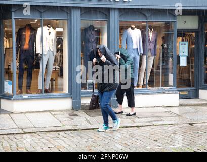 Truro, Royaume-Uni. 18 mai 2021, UNE personne couvre sa tête avec son manteau pour se protéger de la forte pluie à Truro, Cornouailles. La prévision est pour 14C avec des intervalles ensoleillés et une brise douce.Credit: Keith Larby/Alay Live News Banque D'Images