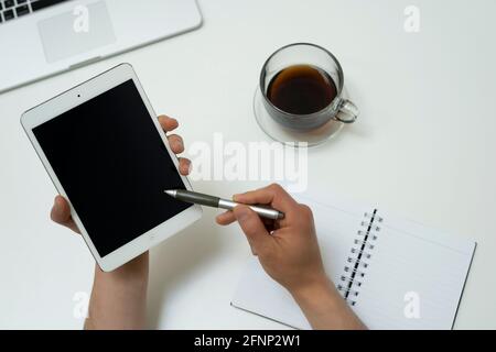 stylet pointant vers une tablette sur l'arrière-plan d'un ordinateur et café Banque D'Images