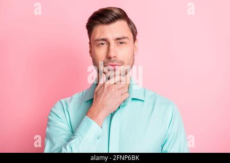 Portrait photo d'un homme d'affaires sérieux et intelligent touchant le menton réfléchi isolé sur fond rose pastel Banque D'Images