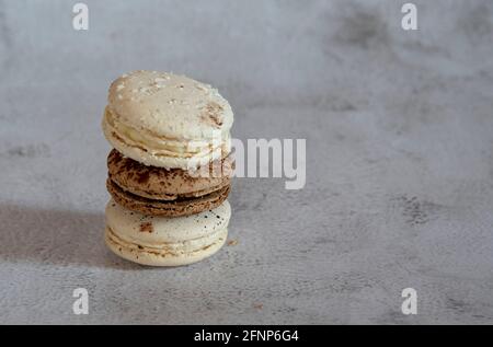 Le café et le macaron à la vanille sont empilés dans une pyramide sur un fond gris clair. Copier l'espace pour le texte, la conception. Banque D'Images