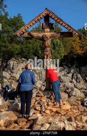 Pèlerins au pied du crucifix au sommet de la colline des apparitions, Podbrdo, Medjugorje, Bosnie-Herzégovine Banque D'Images