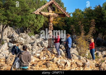 Pèlerins au pied du crucifix au sommet de la colline des apparitions, Podbrdo, Medjugorje, Bosnie-Herzégovine Banque D'Images