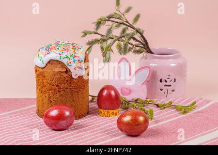 Pâques. Gâteaux de Pâques avec œufs et oreilles de lapin sur fond rose. Pâques. Vase avec branches fleuries. Banque D'Images