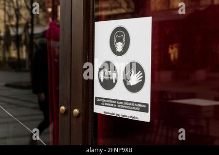 Masques et gants requis avant d'entrer dans l'enseigne du magasin langue serbe Banque D'Images