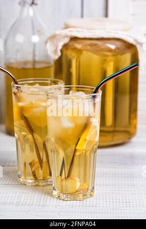 Boisson faite maison au kombucha fermentée avec citron et gingembre. Verres de limonade d'été sur table en bois Banque D'Images