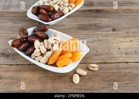 Plateau de fruits secs et de noix assortis sur fond de bois. Copier l'espace. Banque D'Images