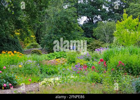 Un homme et une femme prenant une photo de l'ancien pont en pierre de pierre de pierre de pierre de Bressingham Gardens, Bressingham, DISS, Norfolk, Angleterre, ROYAUME-UNI Banque D'Images