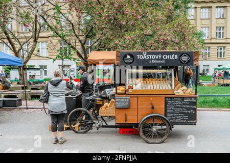 Prague, République tchèque - 15 mai 2021.marché agricole traditionnel dans le quart de Dejvice. Vendeur et client en masques chirurgicaux contre le virus covid19 Banque D'Images