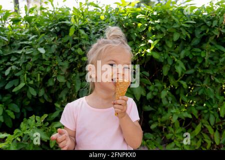 Un petit enfant mange de la glace Banque D'Images