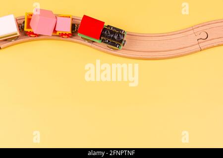 Train de jouets avec chemins de fer en bois incurvés sur fond jaune. Vue de dessus Banque D'Images