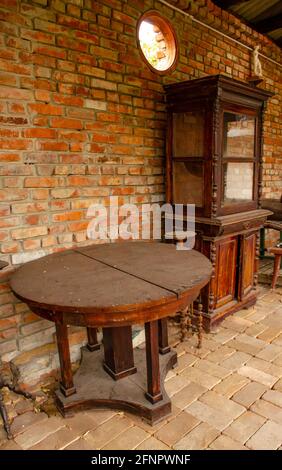 Table et placard bruns anciens sur fond de mur en brique. Objets de conception intérieure ancienne. Vue latérale Banque D'Images