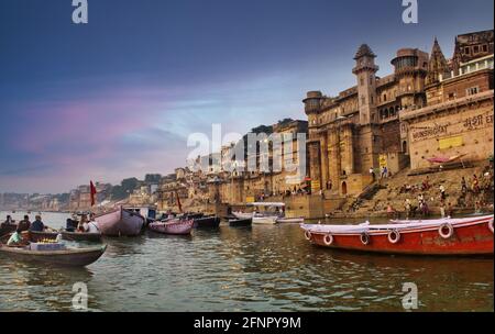 Varanasi, Inde - 01 novembre 2016: Les gens et les touristes sur bateau en bois de visite dans le fleuve Ganges près de Munshi ghat contre l'architecture de la ville antique Banque D'Images