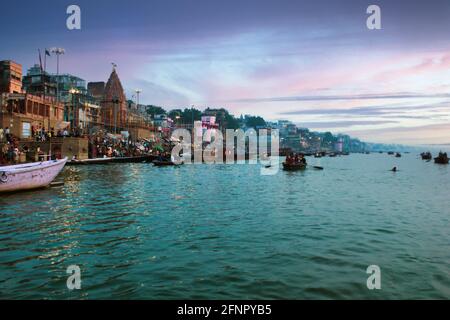 Varanasi, Inde - 01 novembre 2016: Les gens et les touristes sur bateau en bois de visite dans le fleuve Ganges près de Munshi ghat contre l'architecture de la ville antique Banque D'Images