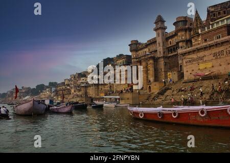 Varanasi, Inde - 01 novembre 2016: Les gens et les touristes sur bateau en bois de visite dans le fleuve Ganges près de Munshi ghat contre l'architecture de la ville antique Banque D'Images