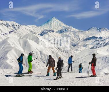 Vue sur les skieurs et le mont Damavand depuis la station de ski de Darbandsar à Téhéran, en Iran. Banque D'Images