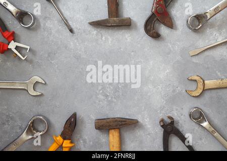 Marteau, clé, gants et autres outils usés et sales sur fond de pierre avec espace de copie. Fête des pères, bricolage, amélioration de la maison, ou jour de travail backgrou Banque D'Images