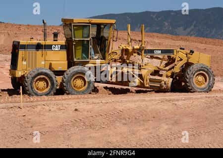 Un conducteur d'équipement lourd utilise une niveleuse Caterpillar 120H pour déplacer la terre sur un chantier de construction de routes à Santa Fe, Nouveau-Mexique. Banque D'Images