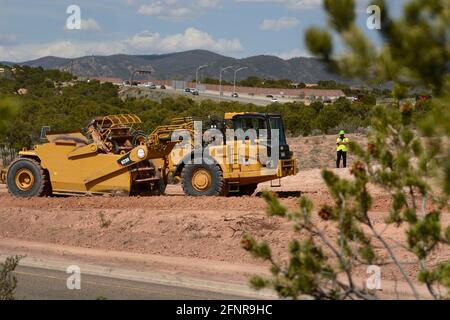 Un conducteur d'équipement lourd utilise une décapeuse automotrice 623H Caterpillar pour éliminer la saleté sur le chantier d'amélioration sur autoroute de Santa Fe, Nouveau-Mexique. Banque D'Images