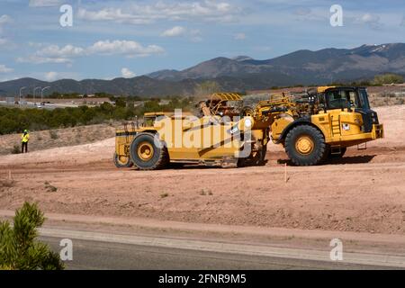 Un conducteur d'équipement lourd utilise une décapeuse automotrice 623H Caterpillar pour éliminer la saleté sur le chantier d'amélioration sur autoroute de Santa Fe, Nouveau-Mexique. Banque D'Images