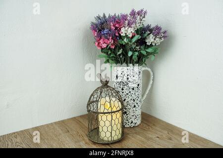 Cage à oiseaux avec bougie et décoration florale sur fond de bois Banque D'Images