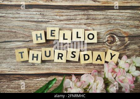 Bonjour Mardi lettre de l'alphabet avec fleur Blooming sur fond en bois Banque D'Images