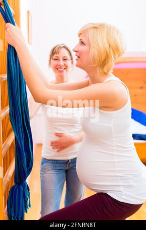 Sage-femme grossesse faire la gymnastique dans sa pratique Banque D'Images