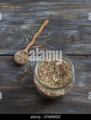 Mélange de céréales pour des craquelins keto sains de graines de chia, de lin, de sésame, de graines de citrouille moulues dans un pot en verre sur fond de bois Banque D'Images