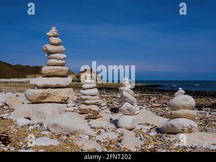 Des tas de galets sur Thornwick Bay, avec l'arche de falaise caractéristique de Thornwick Nabb en arrière-plan Banque D'Images