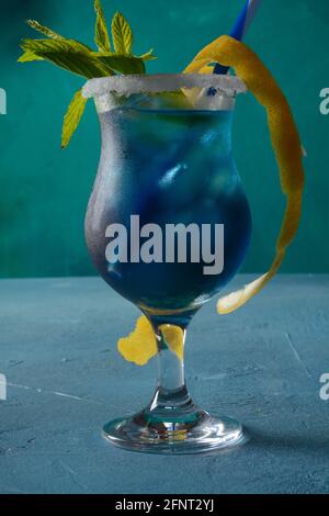 Cocktail lagon bleu avec liqueur bleue de curaçao, vodka, jus de citron et soda, décoré de tranches de citron et de feuilles de menthe. Banque D'Images