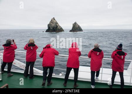 Les touristes regardent les oiseaux pendant que leur bateau de croisière passe Shag Rocks entre Antarctique des îles Falkland et de la Géorgie du Sud Banque D'Images