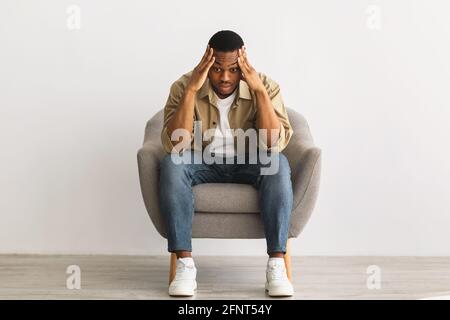 Inquiet Afro-américain Guy pensant s'inquiéter des problèmes, fond gris Banque D'Images