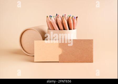 Maquette de carte de visite, papier kraft écologique et un ensemble de crayons de couleur sur fond beige. Concept de papeterie écologique. Recyclable. Photo de haute qualité. Copier l'espace Banque D'Images