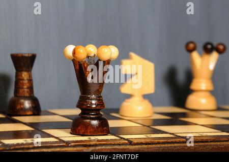 Pièces d'échecs - Reine, chevalier et rook sur un échiquier en bois sur fond gris. Passe-temps intérieur Banque D'Images