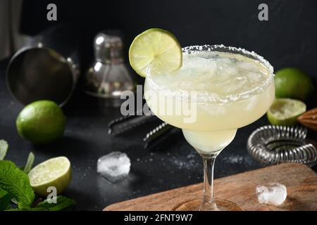 Cocktail de Margarita maison garniture citron vert sur fond noir. Boisson alcoolisée d'été fraîche pour les fêtes. Gros plan. Banque D'Images