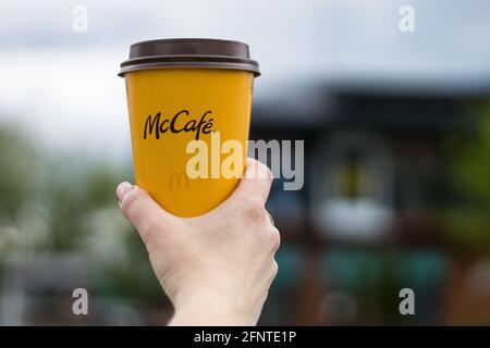 Varsovie, Pologne - 19 mai 2021 : tasse de papier de café McDonald's dans la main d'une femme. Fille tenant une tasse de café McCafe du restaurant de restauration rapide McDonalds Banque D'Images
