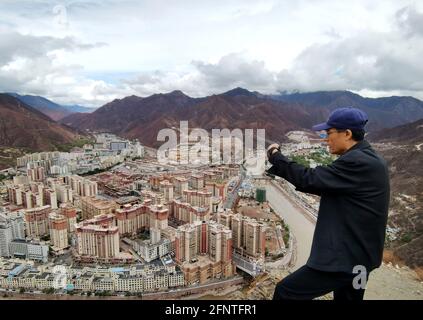 (210519) -- BEIJING, 19 mai 2021 (Xinhua) -- Li Chunmin prend des photos de Qamdo, région autonome du Tibet du sud-ouest de la Chine, 11 mai 2021. Dans la China photo Archive de Xinhua, il y a une photo d'un mandat pris par un journaliste de Xinhua il y a 20 ans - - le premier versement reçu par le Qinghai-Tibet Railway Construction Headquarters. Le mandat n'a pas été signé car l'auteur de la remise a seulement mis 'cadre envoyé pour soutenir le Tibet en 1979' dessus. Vingt ans plus tard, les reporters de Xinhua ont trouvé Li Chunmin, le propriétaire du mandat. Li, 70 ans, a travaillé à Tianjin Dredging Co. Ltd., une filiale de China Communicatio Banque D'Images