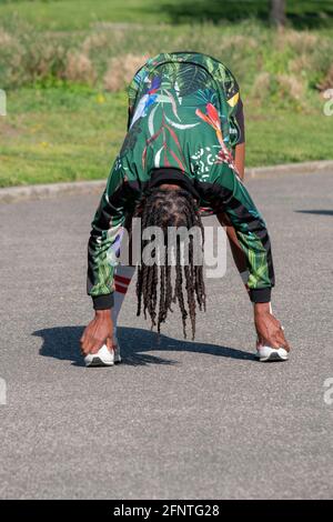 Une femme agile dans ses années 50 à un cours de yoga méditatif dans un parc à Flushing, Queens, New York City. Banque D'Images