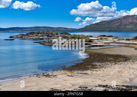 SANDAIG BAY ISLANDS AND BEACHES GLENELG SCOTLAND VUE DE L'AUTRE CÔTÉ DE L' BAIE AU PRINTEMPS DANS DES CANOËS COLORÉS SUR LA PLAGE DE SABLE Banque D'Images