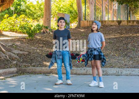 Deux enfants de patinage caucasien, avec leurs patins et portant des vêtements de patinage, très heureux. Banque D'Images